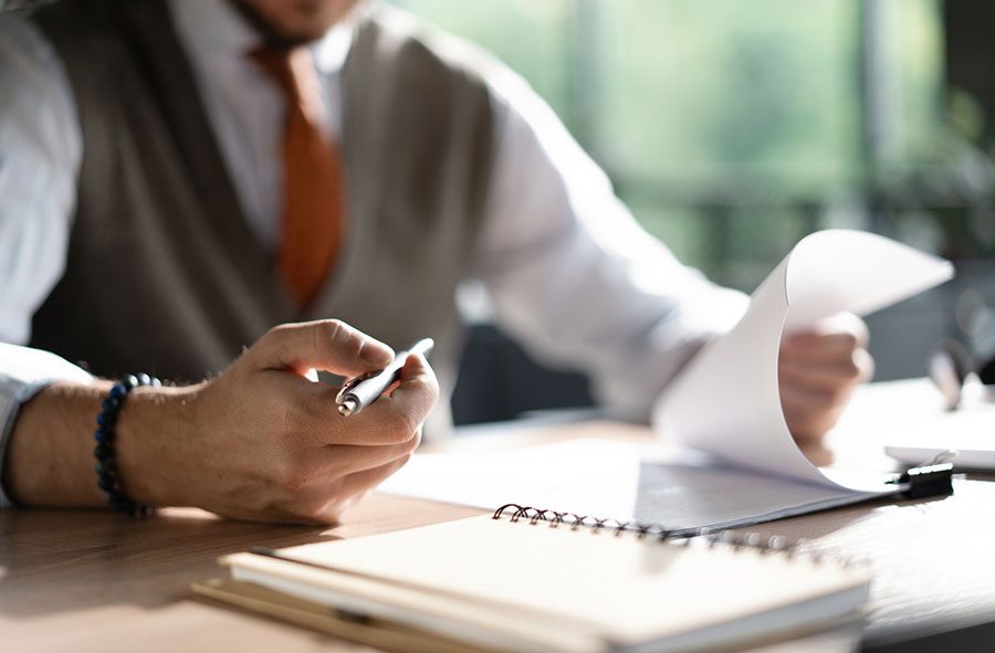 attorney-reviewing-documents-and-taking-notes-at-a-desk