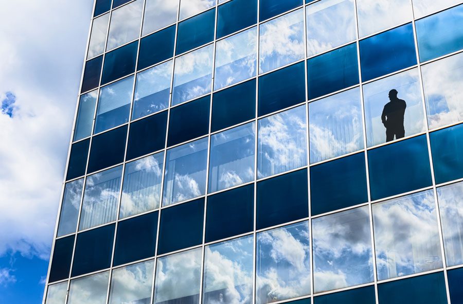 dark-silhouette-in-mirrored-building-window