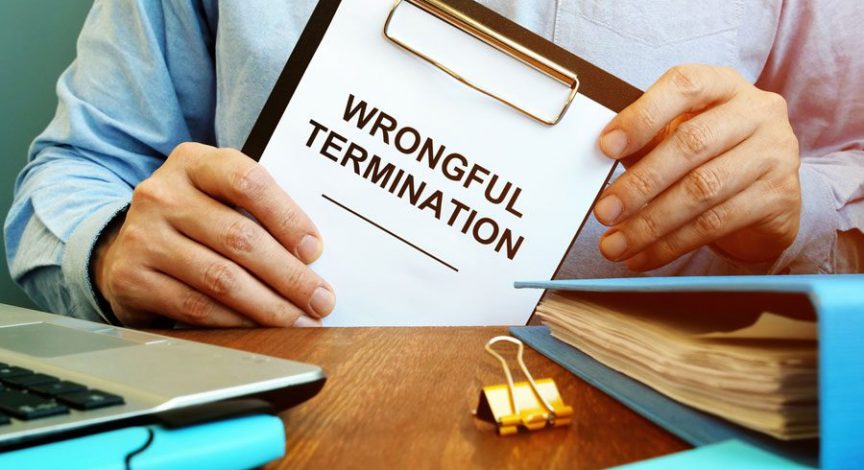 attorney holding a clipboard with a paper that says "wrongful termination"
