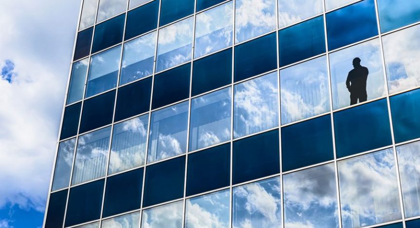 dark-silhouette-in-mirrored-building-window