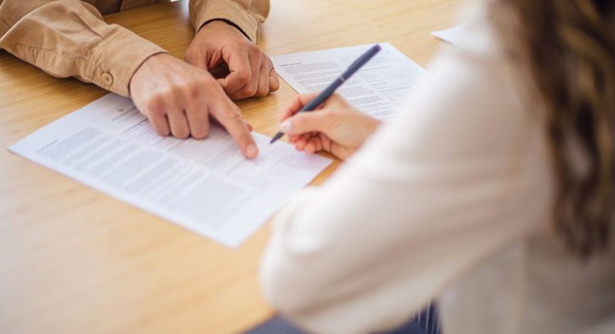 two-people-reviewing-and-signing-a-document-together